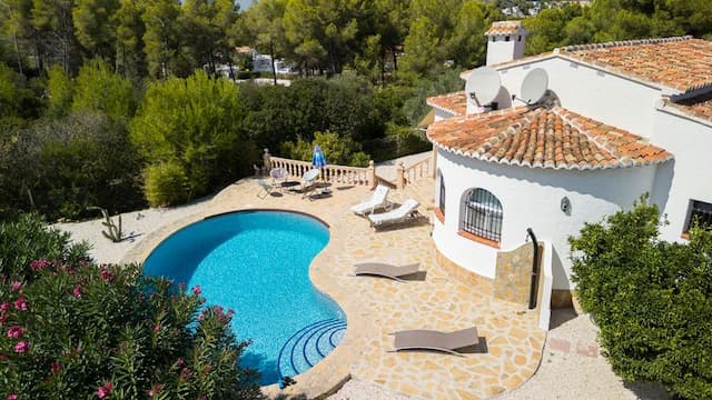 Villa à vendre à Pinosol, Jávea, avec piscine et jardin privés, trois chambres et terrasses exposées sud et sud-ouest.